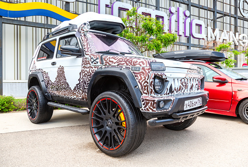 Samara, Russia - May 14, 2023: Tuned off-road vehicle Lada Niva 4x4 parked up on the city street in summer day