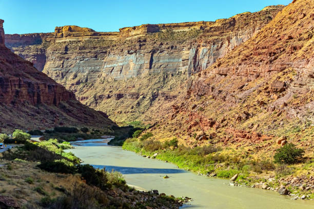 The road runs along the shore of the Colorado River. Utah Red Sandstones. The Colorado River is the most interesting of the turbulent rivers in the USA