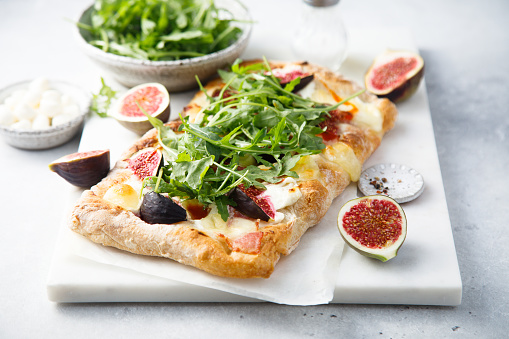 Homemade pizza with figs and arugula