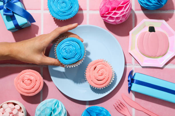 istock Gift boxes, cupcakes and female hand on pink background, top view 2149095379