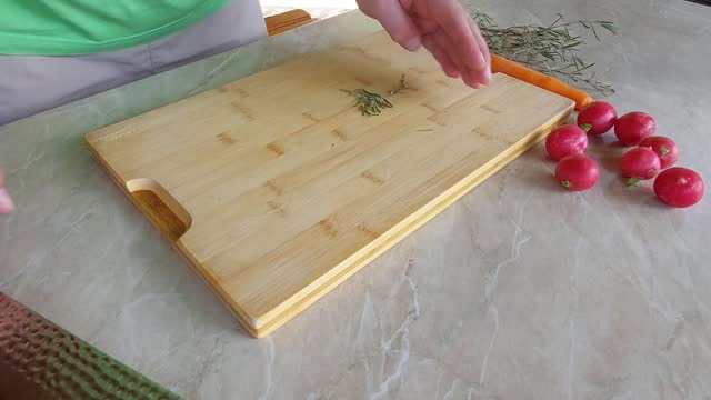 Slicing Fresh Rosemary on wooden board with Japanese ryukiri nikiri knife