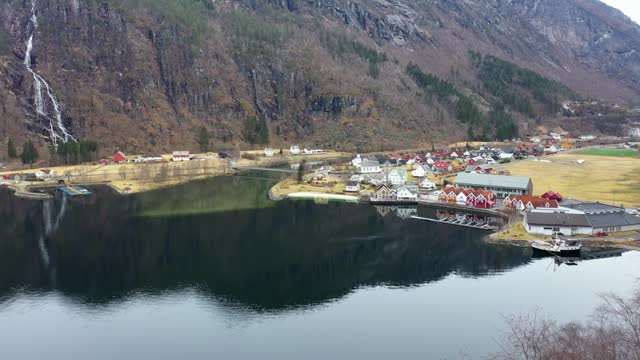 Revealing idyllic town Mo in Modalen Norway from behind tree