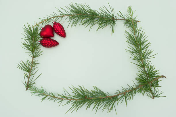 Festive winter solstice, Christmas & New border with snow covered spruce pine fir & red bow on white background, Decorative element for the festive season. Flat lay, top view, copy space.