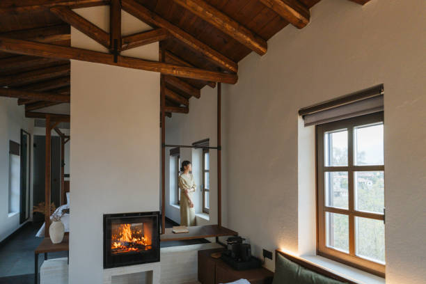 Interior in light colors with a bio fireplace, illuminated by burning sconces on the wall.