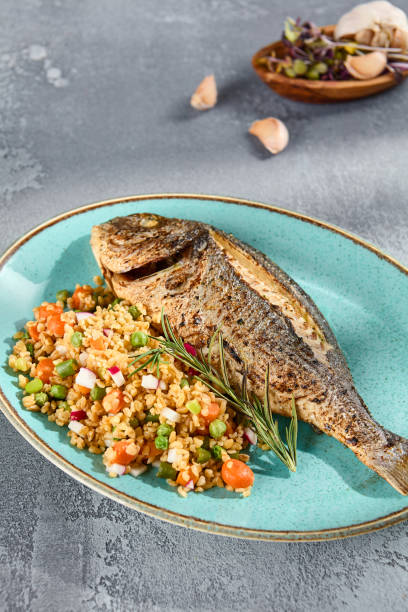 istock Grilled Dorado with Bulgur and Vegetable Medley Elegantly Served on a Turquoise Plate 2149097221