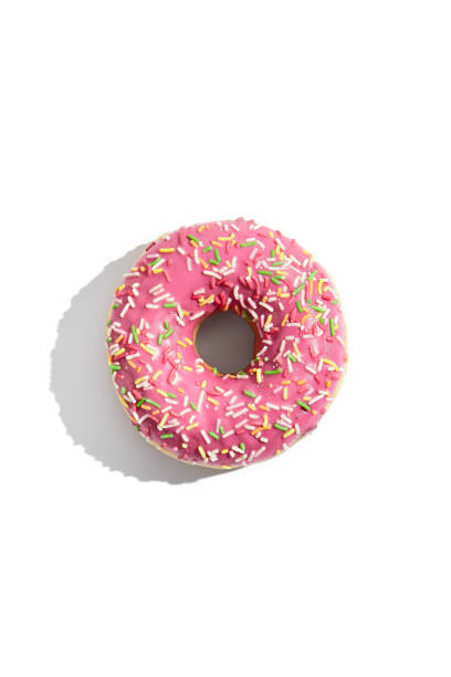 Strawberry frosted donut with white sprinkles, top view isolated on a white background