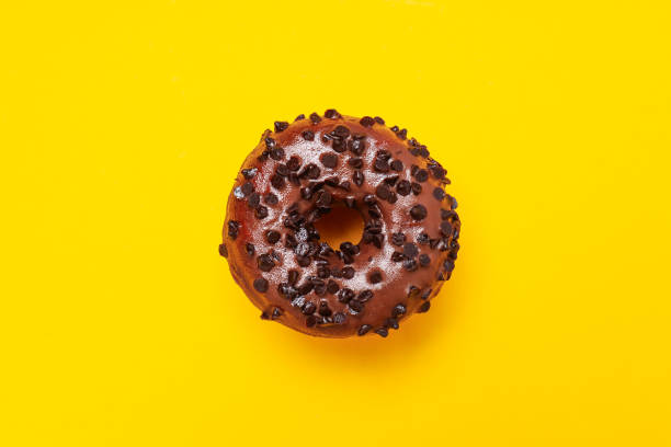 istock Chocolate donut with chocolate chips on yellow background, top view 2149097464