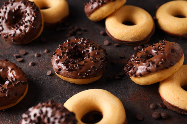 istock Chocolate donuts and chocolate chips on dark gray background, close up 2149097481