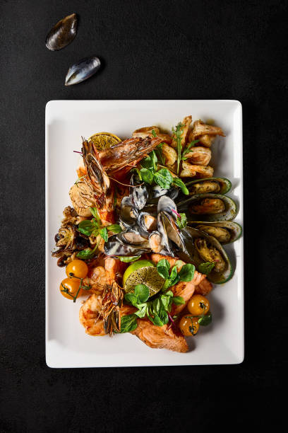 istock Assorted Seafood Delicacies - Mussels, Salmon, Shrimp, and Octopus on a White Plate 2149097613
