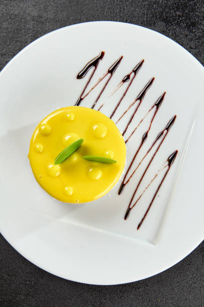 Top view of home made semolina dessert with orange jelly top on wicker mat on white wooden table. Texture and color layered background and home cooking concept.