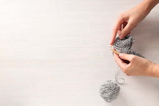 Woman knitting brown threads closeup