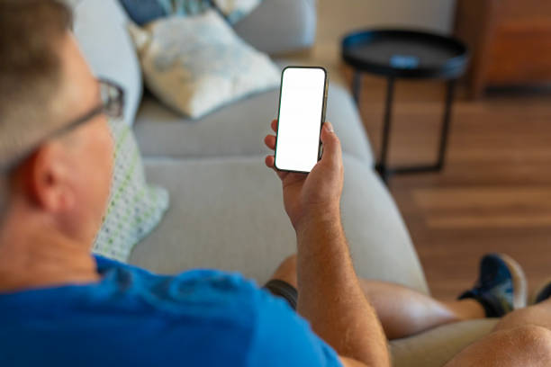 istock Over the shoulder view of a man at home using a mobile phone 2149100227