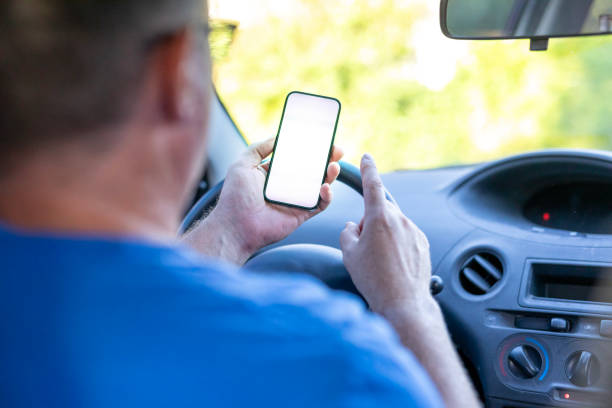 istock Over the shoulder view of a man in a car using a mobile phone 2149100261