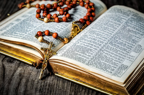 istock Old rosary with golden crucifix on old Bible 2149100552