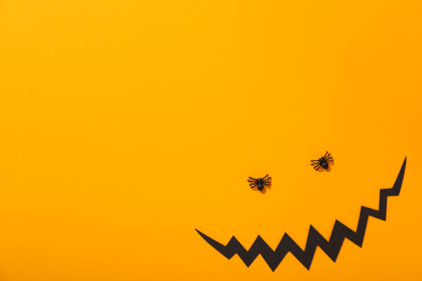 istock Decorative spiders and paper mouth on yellow background, space for text 2149101275