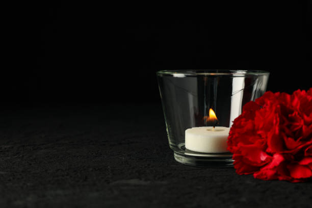 istock Candle in glass and flower on black background, space for text 2149101317