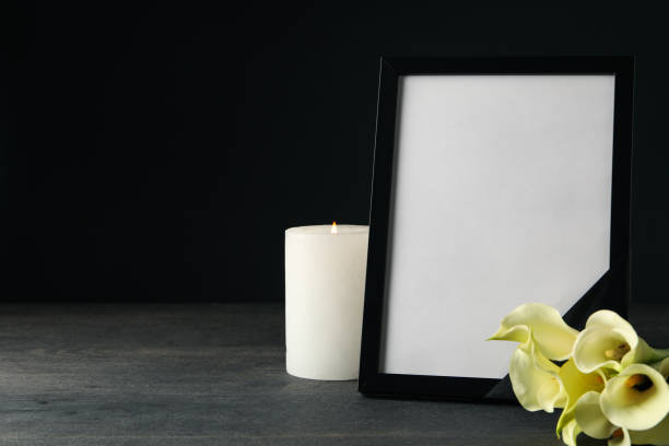istock Photo frame with black ribbon, candle and flower on black background, space for text 2149101920