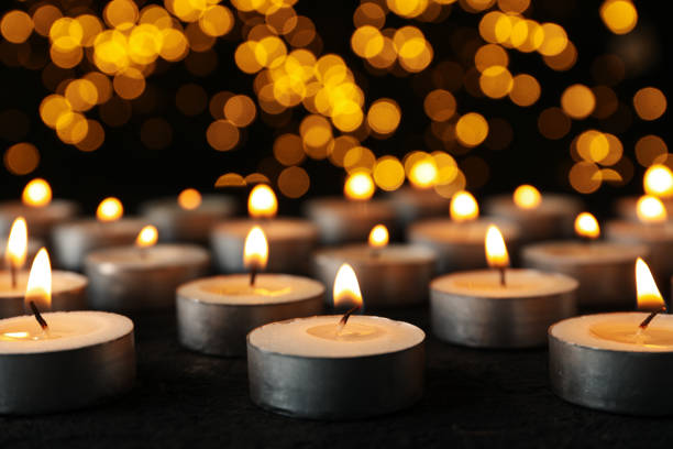 istock Burning small candles on black background, close up 2149101957