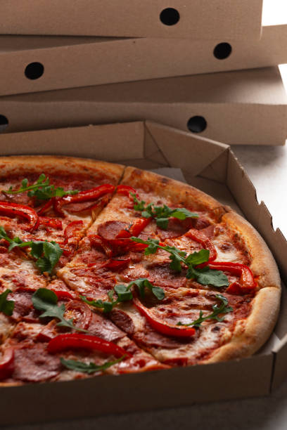 istock Large Pizza in open carton box on kitchen table closeup view 2149102230