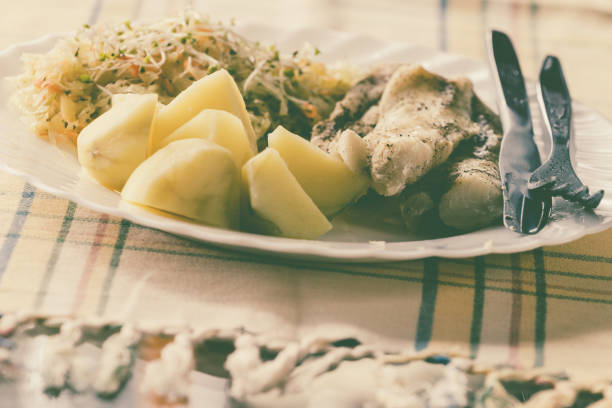 Food. Ready delicious dinner fish meat with salad and potatoes on kitchen home table. Meal time. Indoor.