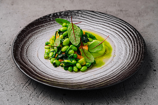 Gourmet edamame bean salad with vibrant greens elegantly presented on a textured plate