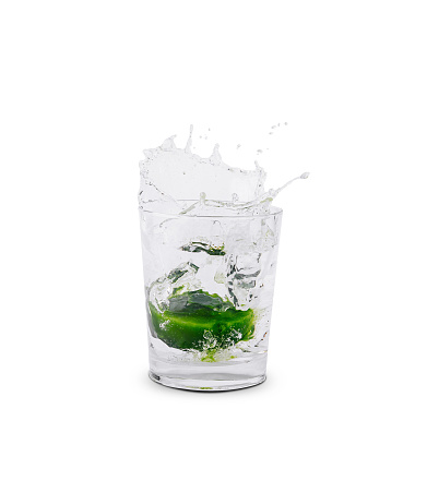 Lime slice dropping into a clear glass of water, creating a dynamic splash, isolated on a white background