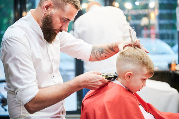 istock Barber using comb and shaver to cut hair. 2149105703