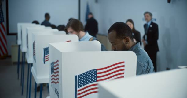 istock African American citizen comes to vote in polling booth 2149105864