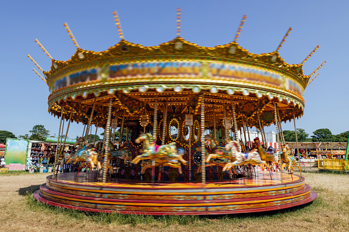 Carousel ride spinning around in motion at a travelling carnival in the North East of England.\n\nVideos are available similar to this scenario.