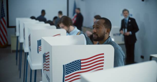 istock African American citizen comes to vote in polling booth 2149106924
