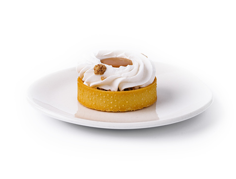 Delicious vanilla cream tart adorned with a hazelnut, isolated on white background