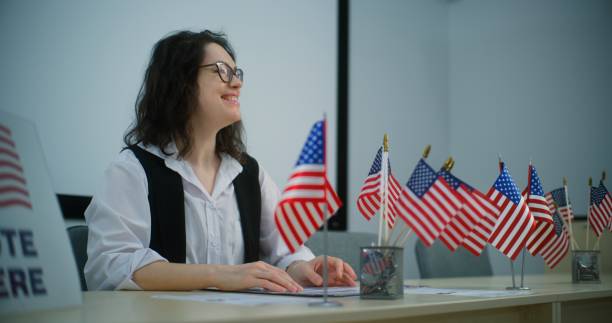 istock Female polling officer talks with person about registration on voting 2149108077