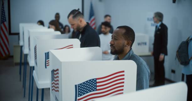 istock African American citizen comes to vote in polling booth 2149108498