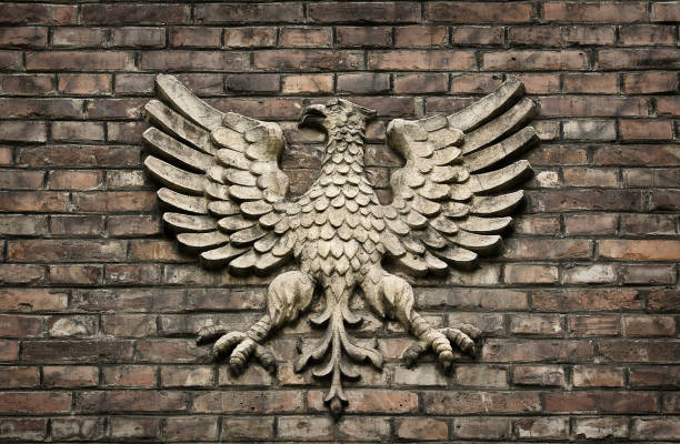 Vintage background with Polish coat of arms eagle on the wall. Old brick wall with bas-relief.