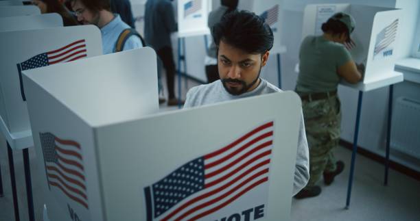 istock Indian man, American citizen votes in booth in polling station 2149109180