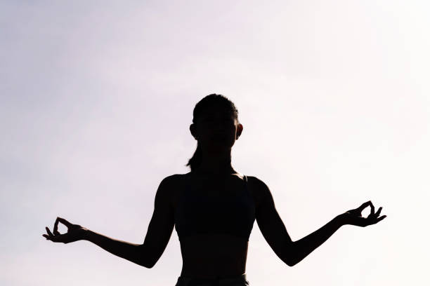 istock backlight of young woman doing yoga meditation 2149109889