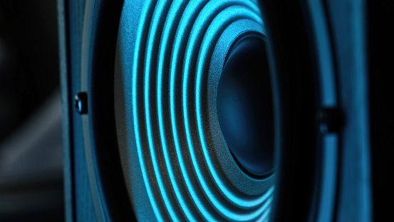 Bass Speaker Vibrating To Music Under Blue Light