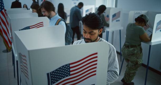 istock Indian man, American citizen votes in booth in polling station 2149111209