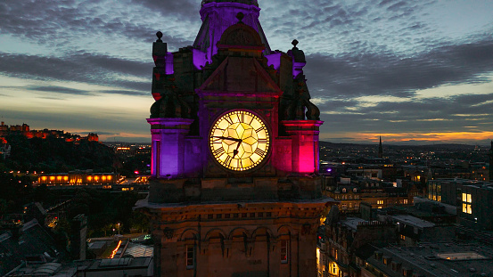 Aerial view of clock tower and scottish flag in Edinburgh old town, Aerial view of Old building in Edinburgh, Edinburgh city centre, Gothic Revival architecture in Scotland, Flag of Scotland in Edinburgh, Edinburgh city scotland at night