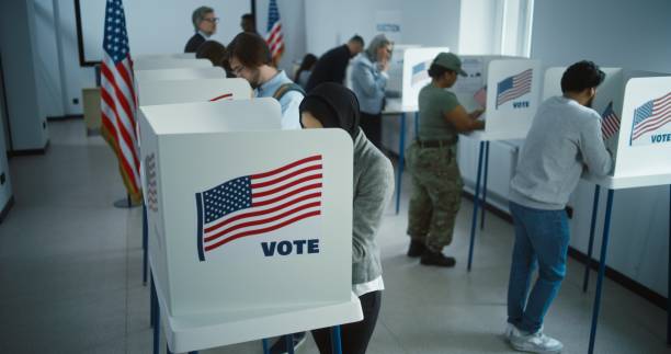 istock Arabic woman in hijab votes in booth in polling station office 2149113697