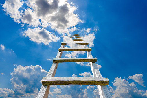 The way to success concept.Wooden ladder leading high up to the heaven.Blue sky and white clouds, success concept.Copy space.