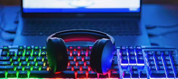 istock Pro gaming illuminated desk, headset, keyboard, computer neon lights. Cyber sport equipment laying on desktop, ready for online video gaming.Dark shot.Banner,advertisement. 2149113887