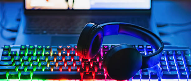 istock Gamer workspace concept.Gaming gear, keyboard, joystick, Headset illuminated background with RGB Color.Dark shot.Banner,advertisement. 2149114250