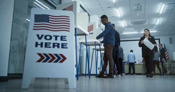 istock Vote here sign on the floor in polling station office 2149114794