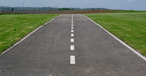 empty airport runway, asphalt with white lines