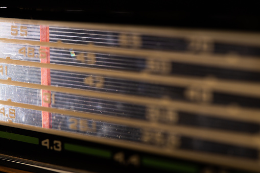 Vintage stereo fm tuner radio scale close up. Listen to music conceptClassic radio tuner panel close-up. Black background