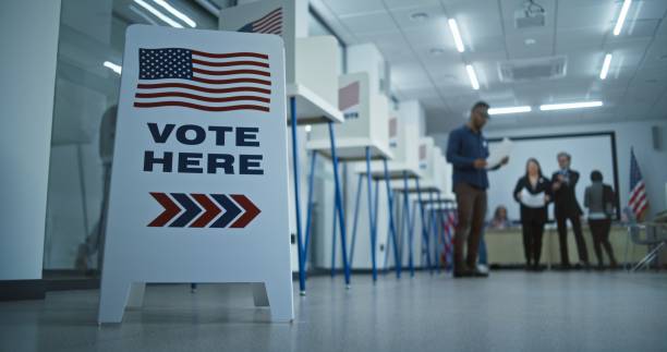 istock Vote here sign on the floor in polling station office 2149116421