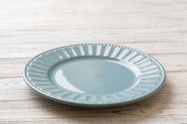 Perspective view of empty grey plate on cement background. Empty space for your design.