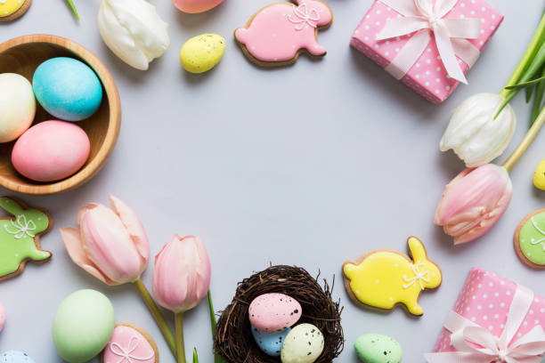 istock Easter frame with eggs, gift box and tulip on a colored background. The minimal concept. Top view Happy Easter composition. Card with a copy space of the place for the text 2149116782
