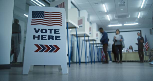 istock Vote here sign on the floor in polling station office 2149117129